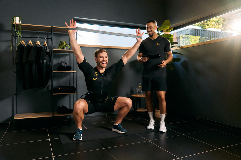 Training van een man met een personal trainer in een SYMBIONT EMS-studio, met positieve energie, motivatie en persoonlijke training en coaching.